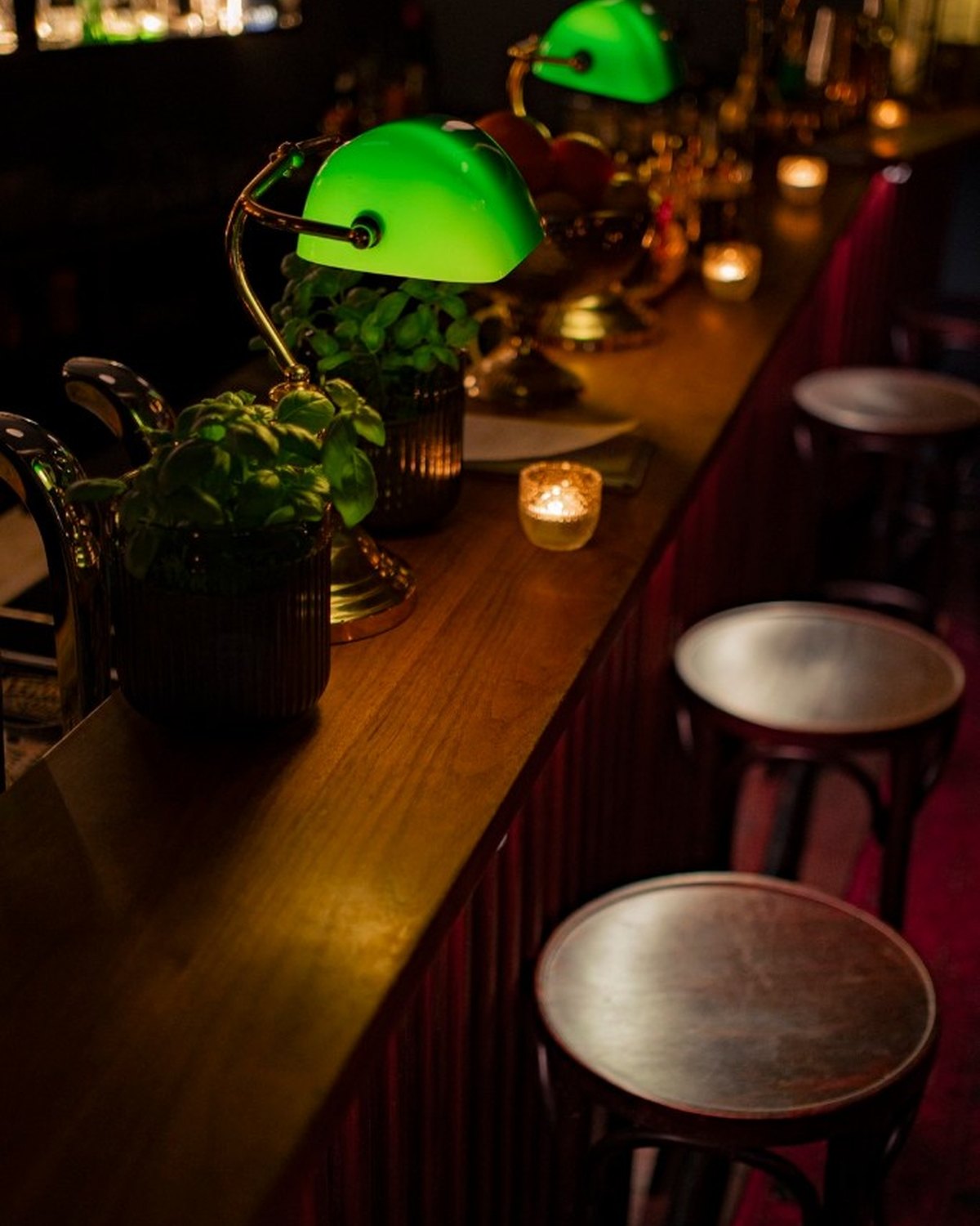 The bar at Saint George, green banker's lamps along the counter